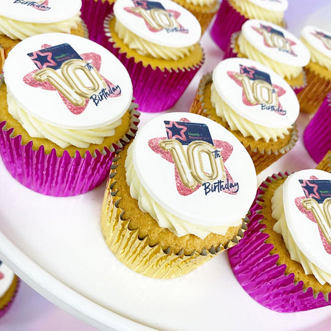 Cupcakes with '10th Birthday' branded toppers in pink and gold cases