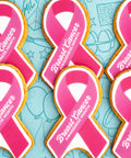 Pink breast cancer awareness ribbon-shaped biscuits with white lettering, saying "Breast Cancer awareness month"