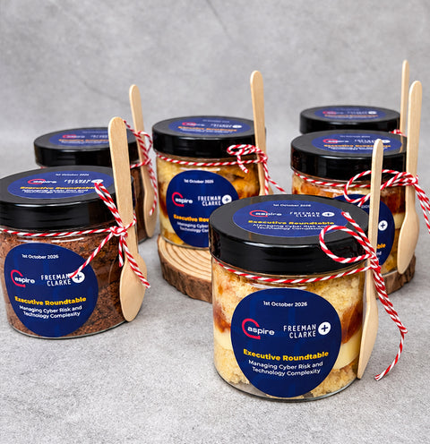 Branded cake jars for a company event with company sticker showing the logo and marketing message. Each cake jar shown with a spoon.