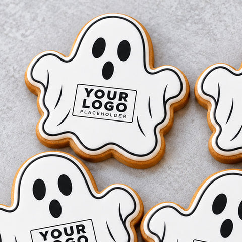 Halloween ghost gingerbread biscuits with company logos, ready to be individually wrapped