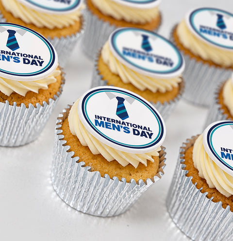 International Men's Day cupcakes with blue tie toppers and vanilla buttercream in silver foil cases