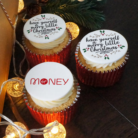 Cupcakes for Christmas , half with a company logo and half with a Christmas design saying "have yourself a Merry little Christmas."