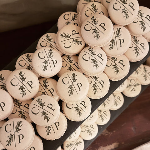 personalised macarons for a wedding with the couples initials dark green and foliage print. 
