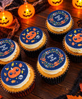 Trick or Treat Halloween cupcakes with pumpkin, skull and autumn leaf toppers on a dark wooden table